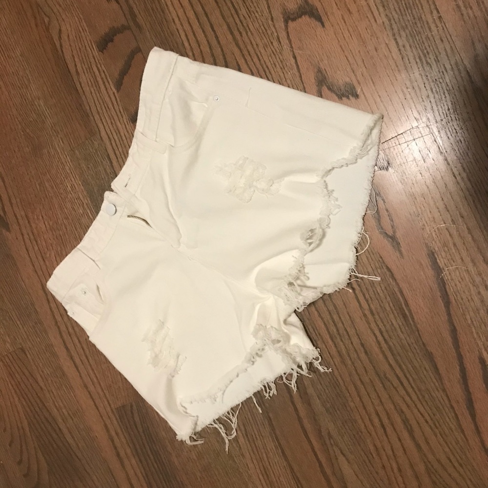 A pair of white ripped jean shorts